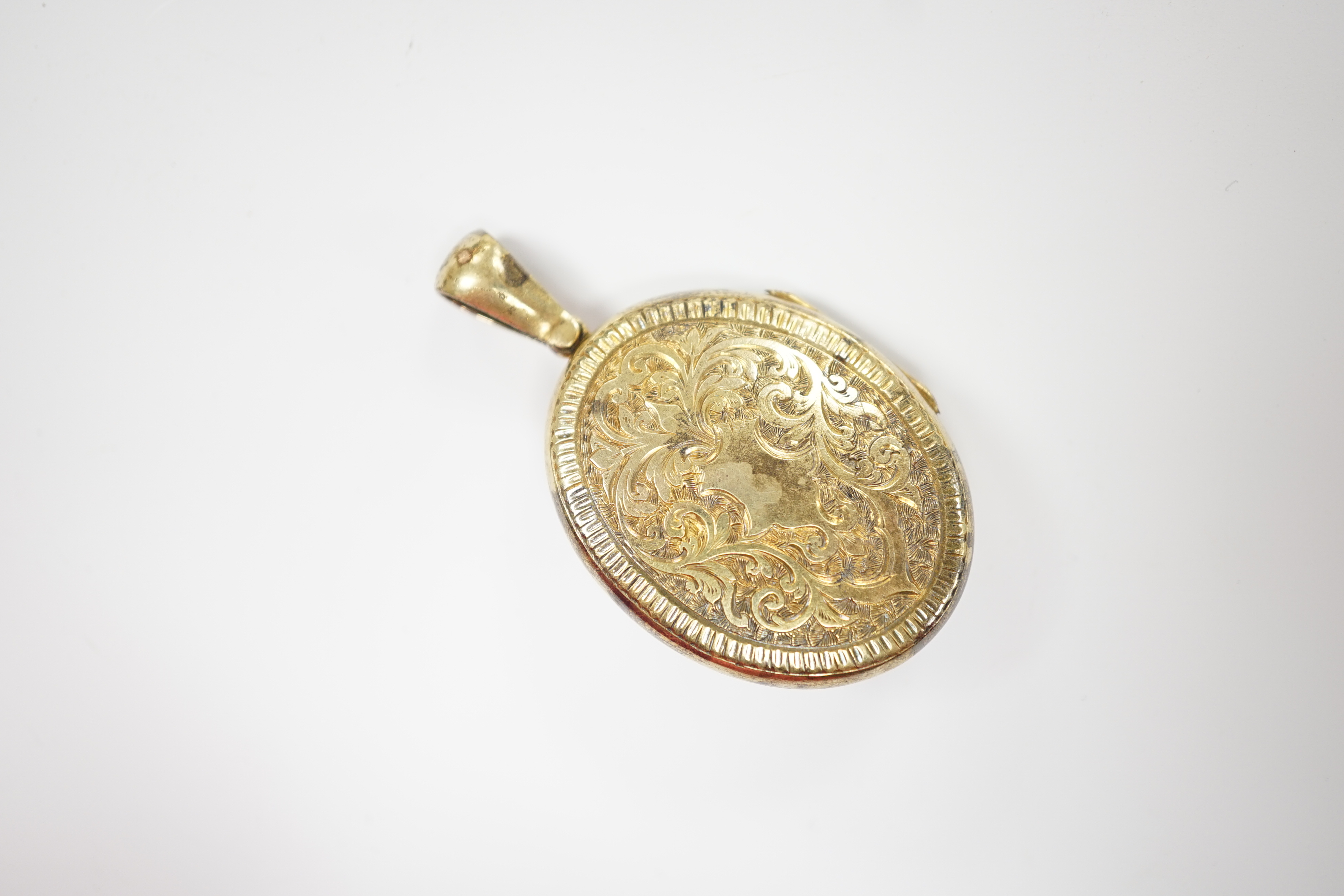 A late Victorian engraved yellow metal, seed pearl and gem set oval locket, overall 50mm, gross weight 13.5 grams.